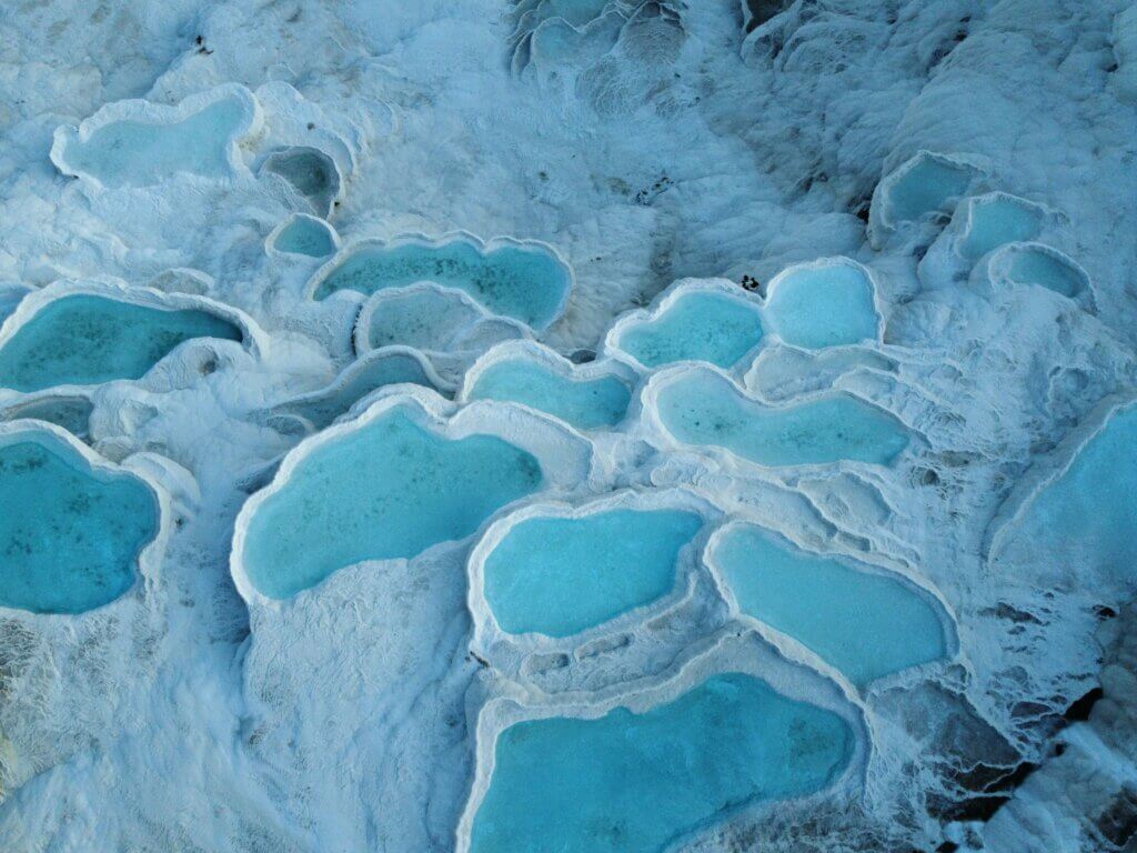 White travertine terraces filled with turquoise thermal water in Pamukkale, Turkey.