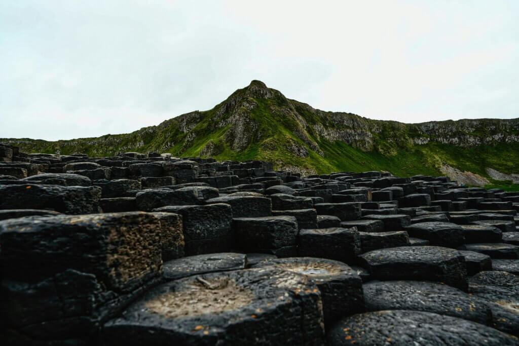 Hexagonal basalt rock columns forming a natural pathway along the coast in Northern Ireland.