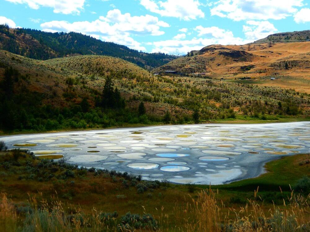 Unique lake in British Columbia with circular mineral deposits creating a polka-dot pattern.