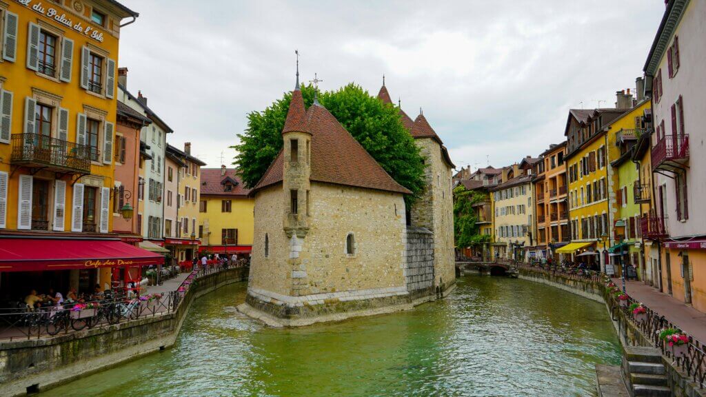 Canals winding through Annecy’s medieval Old Town in France with colorful facades and flower boxes overhanging the water