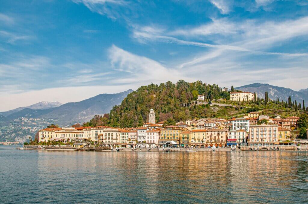 Panoramic view of Bellagio on Lake Como, Italy, with pastel houses clustered on a lakeside promontory and mountains in the background