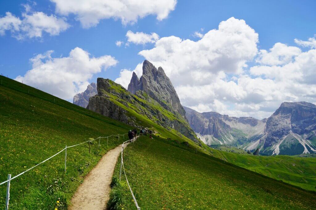 Scenic valley view of Ortisei in Italy’s Val Gardena, showing flower-adorned chalets and the dramatic Dolomite peaks above